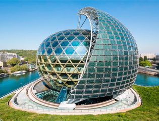 Здание-гигантский шар с вращающимся солнечным парусом из солнечных батарей