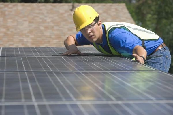Рабочий обслуживания измеряет солнечную батарею на крыше — стоковое фото