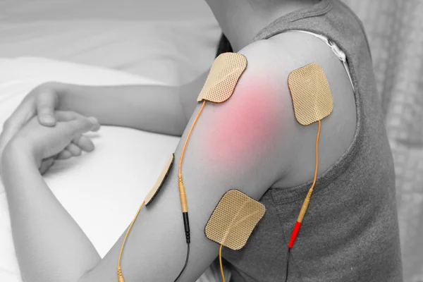 Электроды десятков устройство на плече, десятки терапия, нервных окончаний — стоковое фото