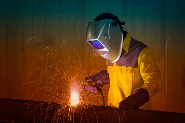 Промышленный работник безопасности оборудования и защитной маски сварки стальных конструкций в строительстве завода — стоковое фото