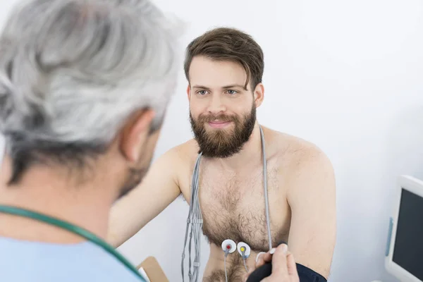 Пациент, глядя на врача во время прохождения электротерапия — стоковое фото
