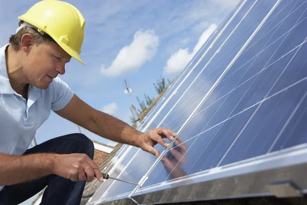 Человек, устанавливающий солнечные батареи — стоковое фото